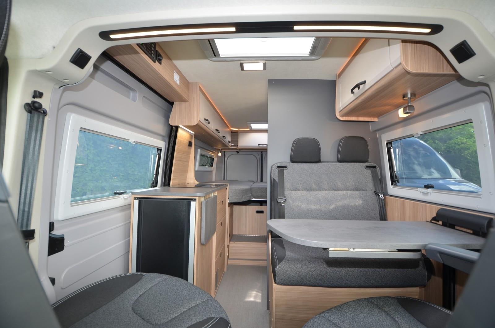 Pössl Summit 600L. Les Summit revêtent un nouveau décor San Marco : cloison grise, mobilier décor bois, portes de placard blanches.